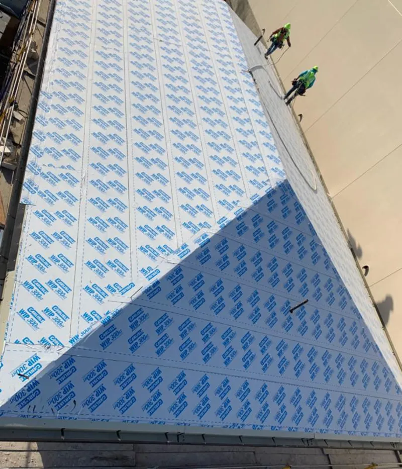 Professional roofers installing underlayment on a metal roof in Lakeland North